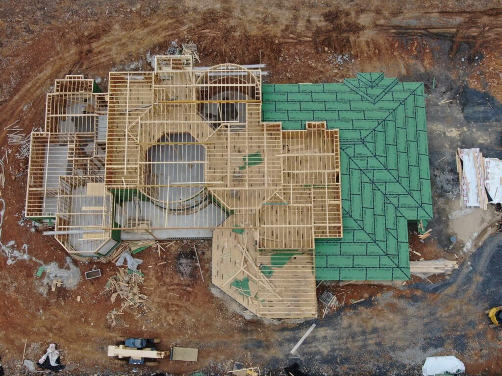 Aerial view of luxury custom home construction and framing progress in Austin, TX