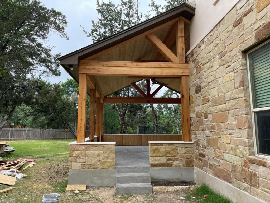 Finished cedar patio cover with vaulted ceiling and exposed timber beams in Austin, Texas