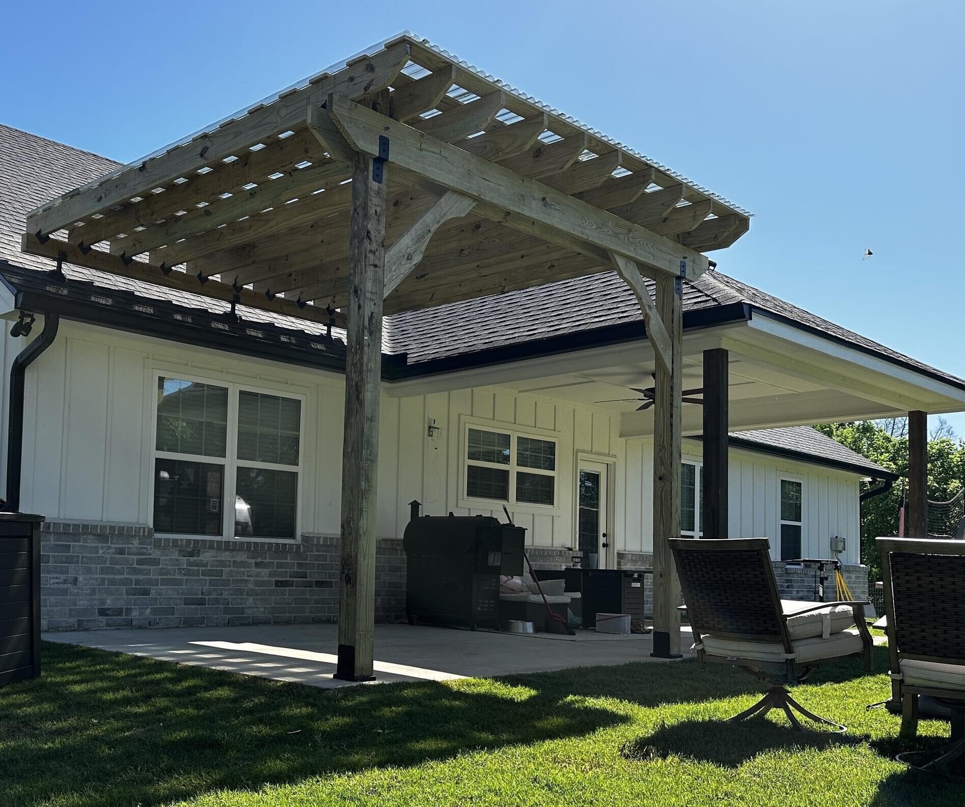 Freestanding pergola with weather-resistant roofing panels for backyard outdoor living area in Austin, TX