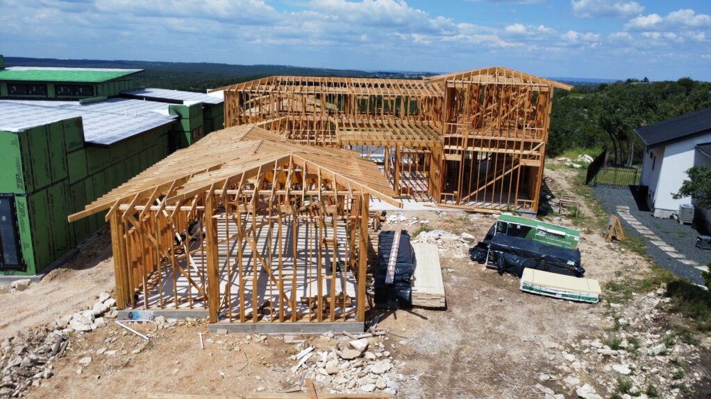 Drone view of luxury custom home roof framing and structural development in Austin Texas